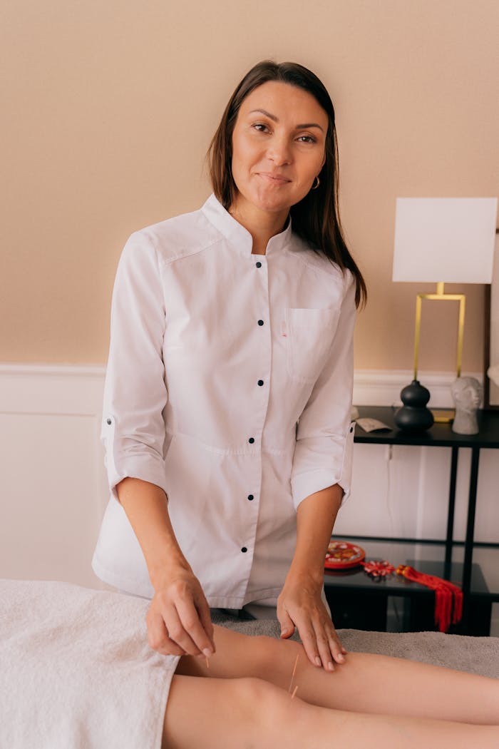 Female acupuncturist performing treatment in a modern clinic setting, focusing on wellness and relaxation.